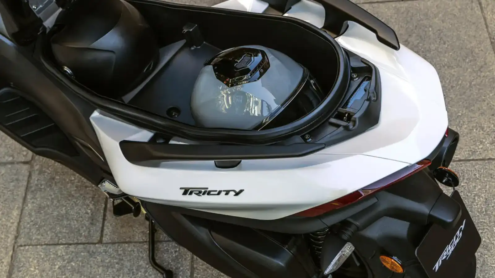 Compartimento sob o banco mostrando a capacidade para dois capacetes