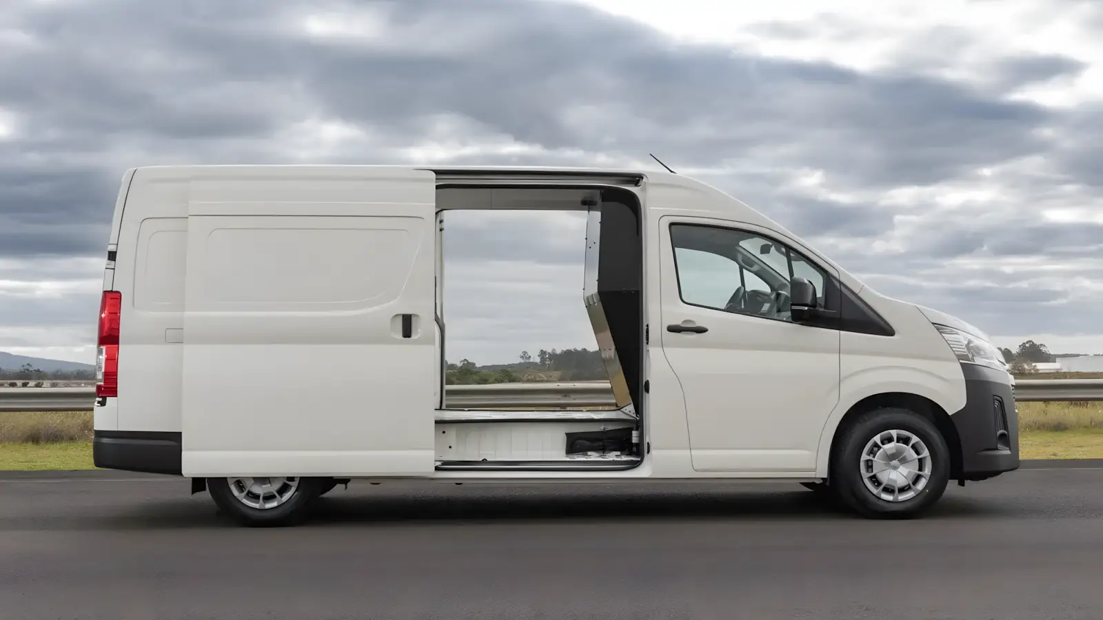 Toyota Hiace Furg&atilde;o 2026 branca vista lateral com portas abertas
