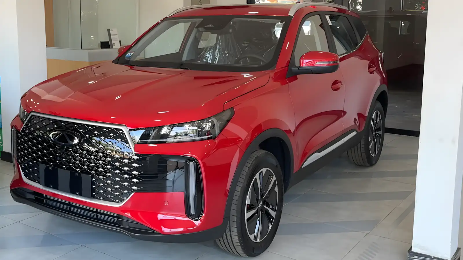 Chery Tiggo 5X HEV 2027 vermelho visto de perfil em concessionária no Paraguai