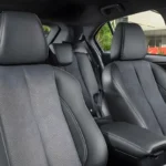 Interior do Eclipse Cross Black 2027 com bancos em camurça cinza e console escurecido